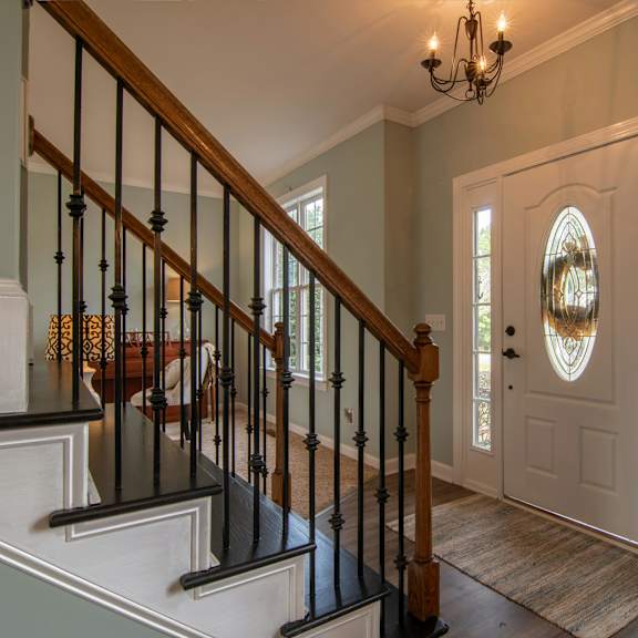 a staircase with a black railing and a light brown carpet.