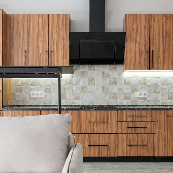 a modern kitchen with wooden cabinets and a black range hood.