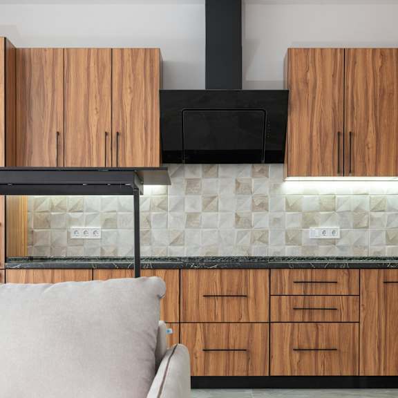 a modern kitchen with wooden cabinets and a black range hood.