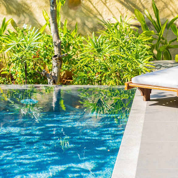 a pool with a chair and table beside it.