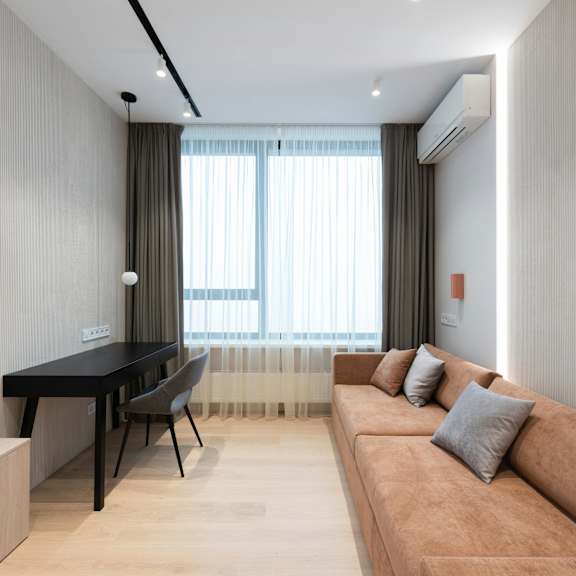 a living room with a brown couch, a black table, and a television.