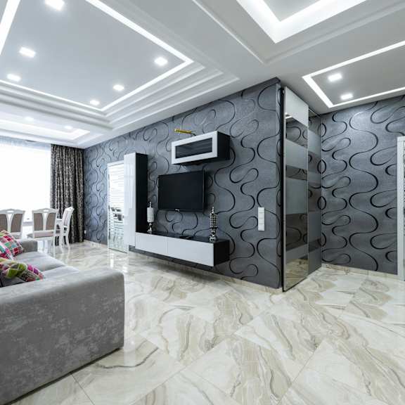 a modern living room with a grey sofa and a television.