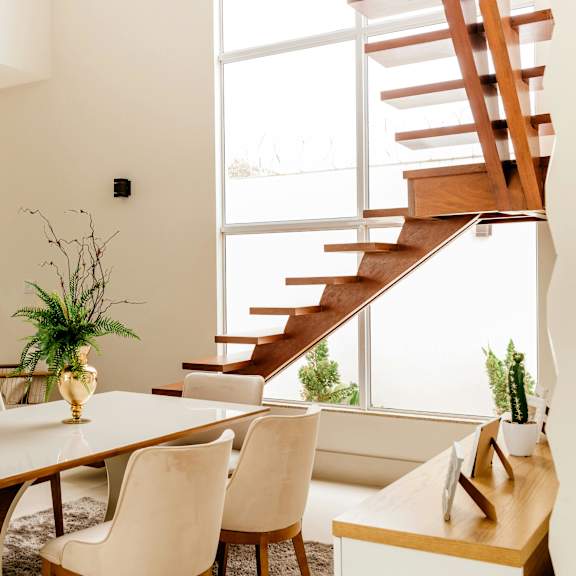 a dining room with a wooden table and white chairs.