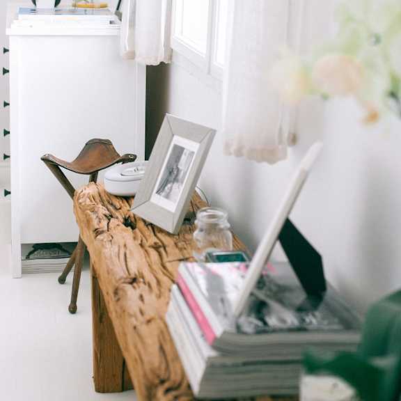 a white dresser with a lamp and a picture frame on top of it.