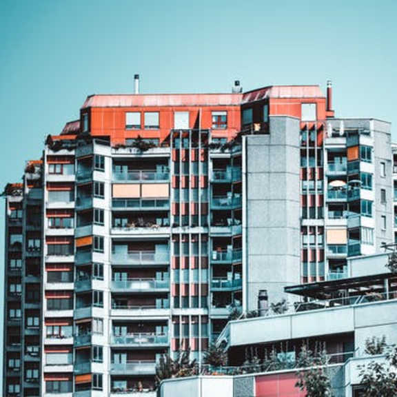 a tall building with a red top stands out against a clear sky.
