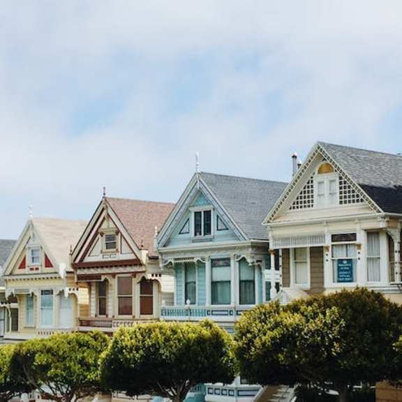 a row of victorian style houses with green shutters.