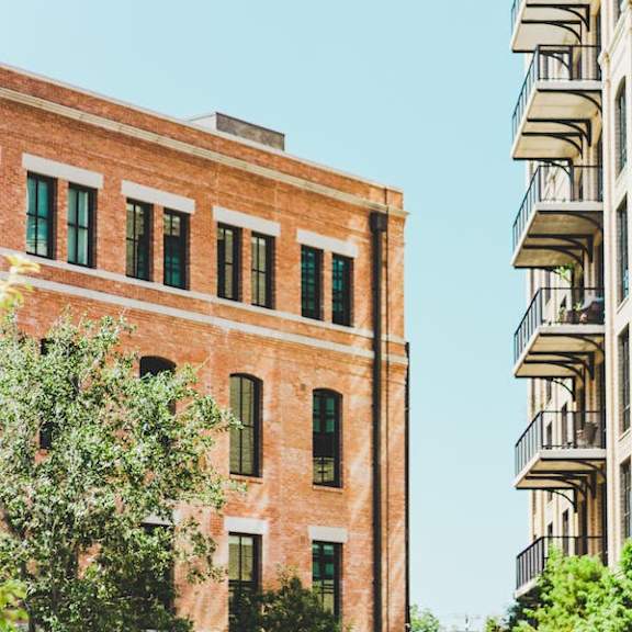 a red brick building with green trees in front.