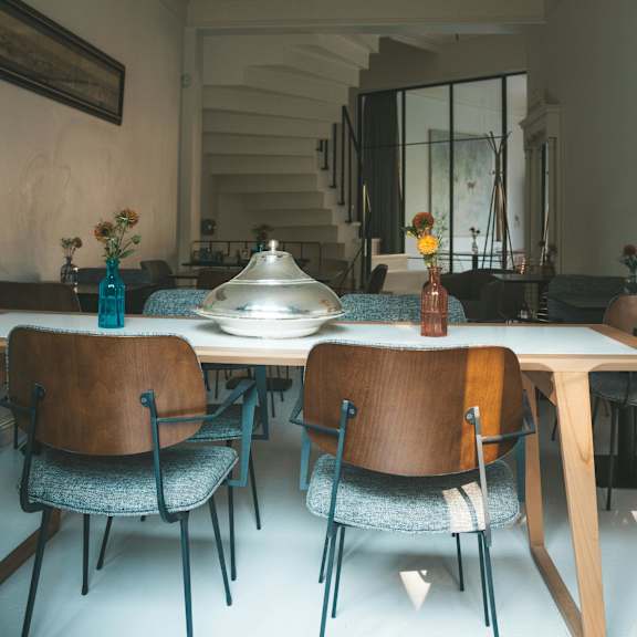 a dining room with a table set for two and a chandelier hanging from the ceiling.