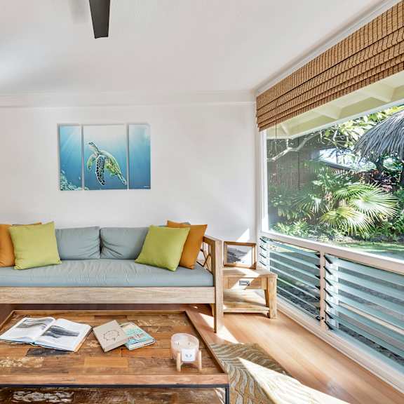 a living room with a couch, a coffee table, and a painting on the wall.