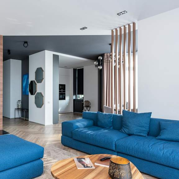 a blue couch is in the middle of a modern living room.