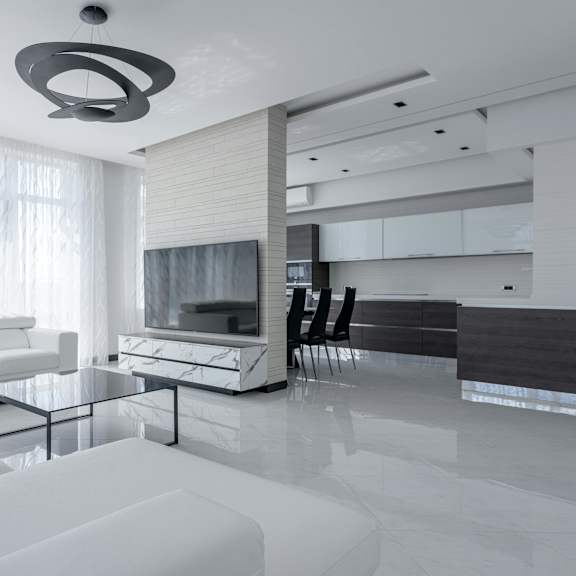 a modern living room with white furniture and a large window.