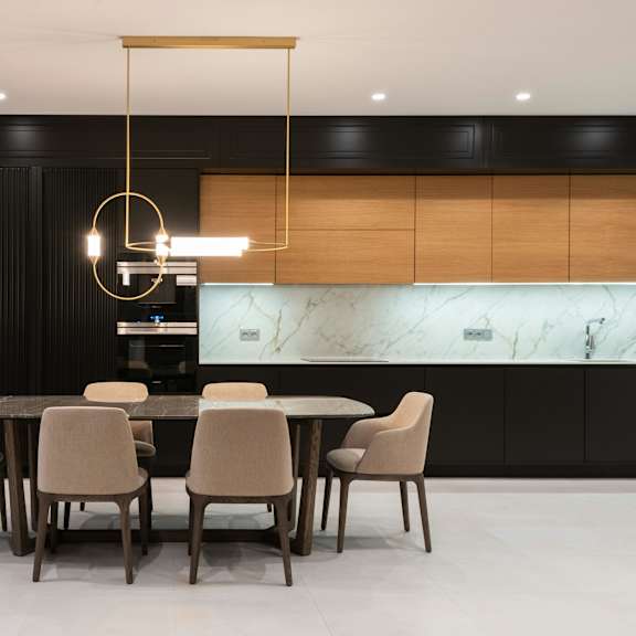 a modern dining room with a marble backsplash and a round pendant light.