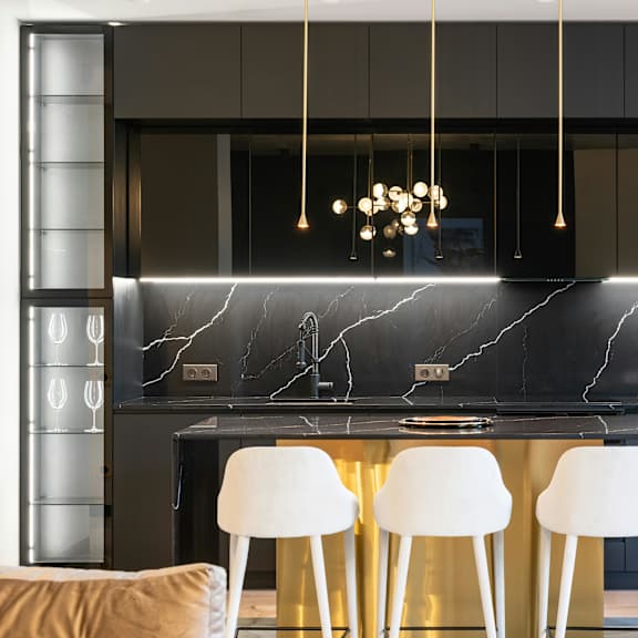a modern kitchen with a marble backsplash and white chairs.