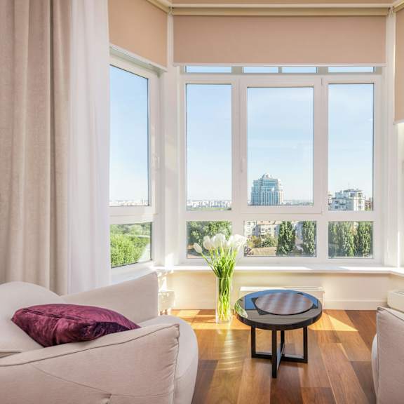 a living room with two white couches and a table with a vase of