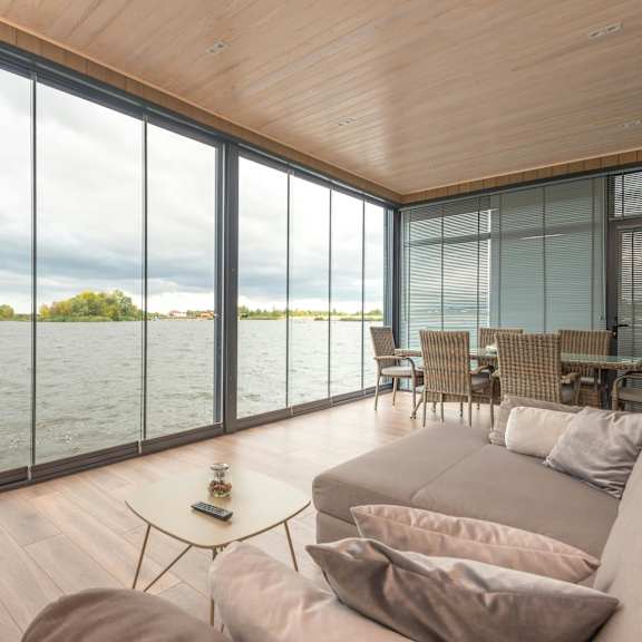 a living room with a couch and a table overlooking the water