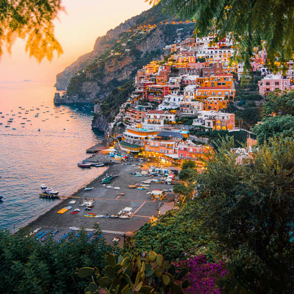a beautiful coastal town with colorful buildings and boats in the water.