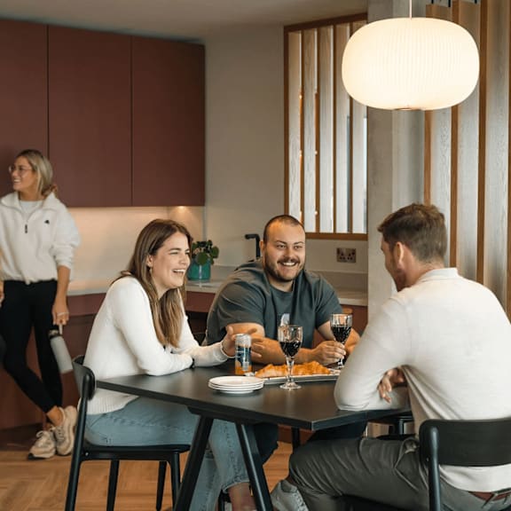a group of people are gathered around a table eating and drinking. at cherrywood apartments, d18 vy3v, dublin 18