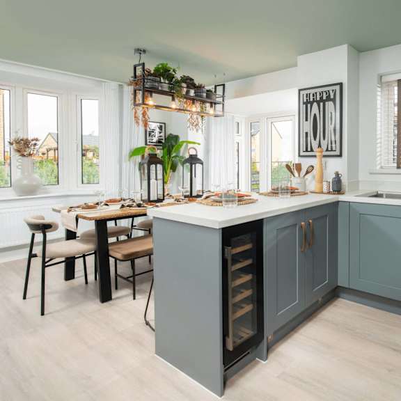 a kitchen with a table set for four and a window with a view of a house.