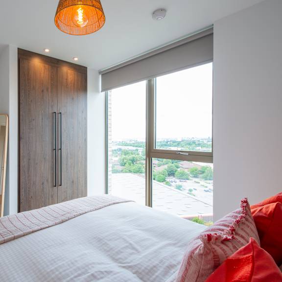 Thumbnail 5 of 8 A bedroom with a large bed and a view of the outside.
