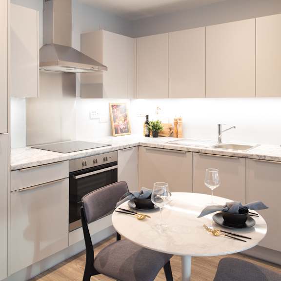 Thumbnail 2 of 5 A modern kitchen with a dining table set for two.