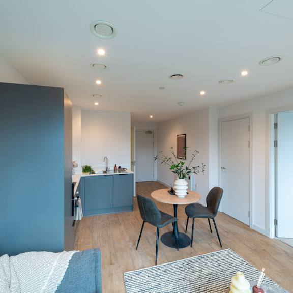 Thumbnail 5 of 11 A modern living room with a dining area and kitchen in the background.