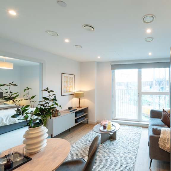Thumbnail 2 of 11 A modern living room with a large window and a grey rug.