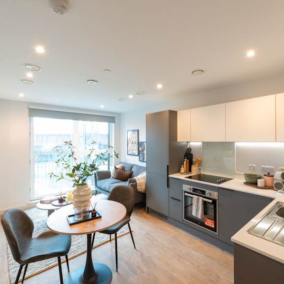 Thumbnail 1 of 11 A modern kitchen with a dining table and chairs.