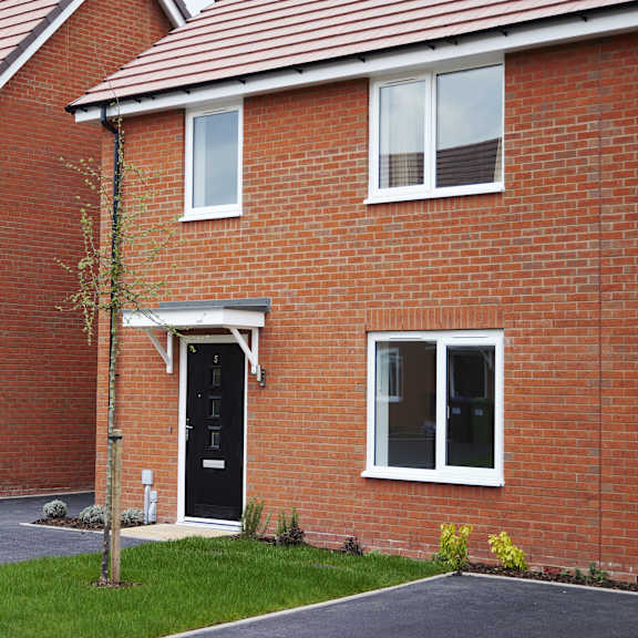 Thumbnail 1 of 5 a red brick house with a black door and a driveway