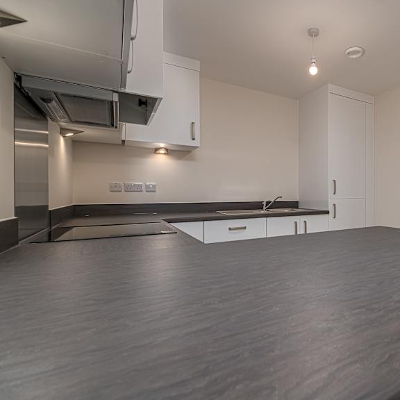 Thumbnail 6 of 12 A modern kitchen with a large island in the middle.
