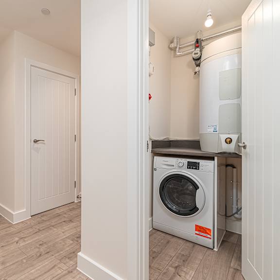Thumbnail 10 of 12 A modern kitchen with a washing machine in the laundry room.