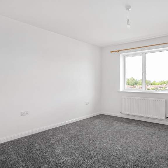 Thumbnail 2 of 5 an empty room with a window and white walls