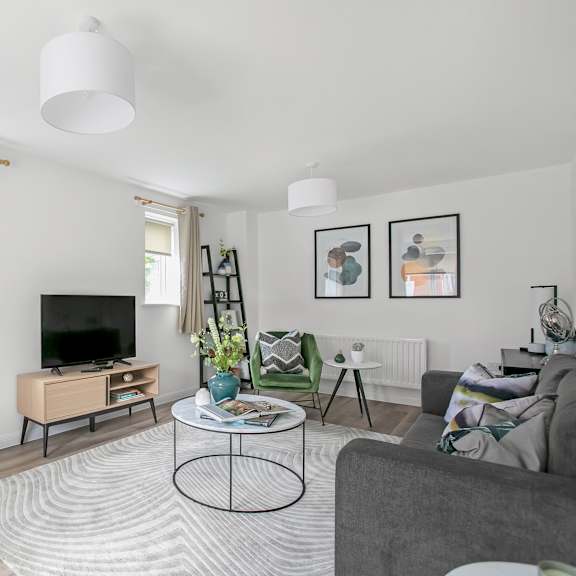 Thumbnail 1 of 5 a living room with white walls and green furniture and a television