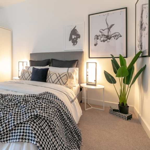 Thumbnail 1 of 6 a bedroom with a bed with a black and white comforter at The Keel Apartments, Liverpool