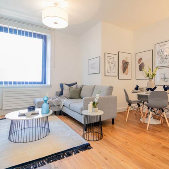 Thumbnail 2 of 6 a living room with a couch and a dining room table at The Keel Apartments, Liverpool, L3 4GE