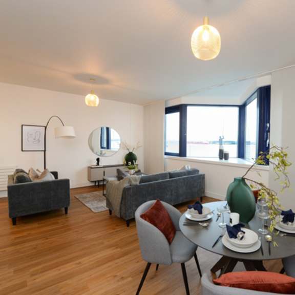 Thumbnail 4 of 8 a living room with a table and chairs and a window at The Keel Apartments, Liverpool