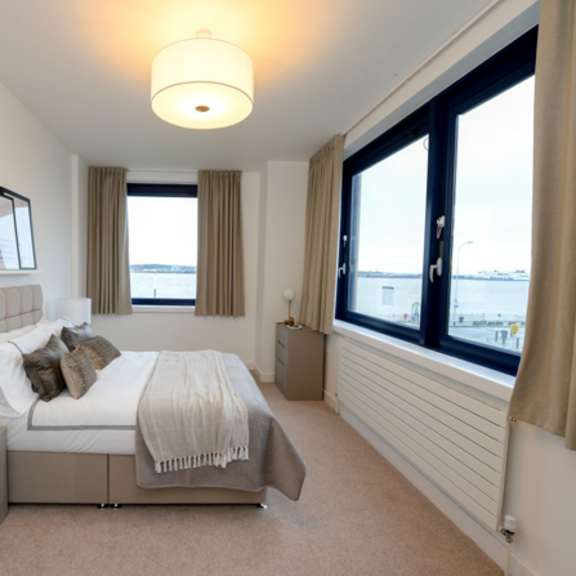 Thumbnail 1 of 8 a bedroom with a bed and a large window at The Keel Apartments, Liverpool, L3 4GE