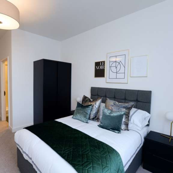 Thumbnail 3 of 8 a bedroom with a bed and a black and white bedspread and pillows at The Keel Apartments, Liverpool