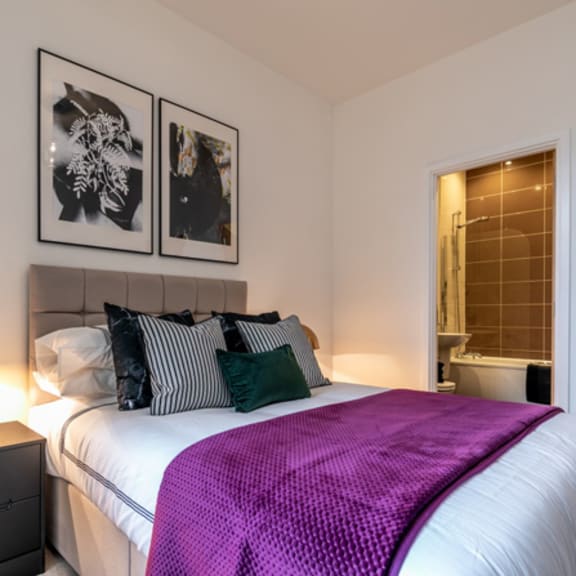 Thumbnail 2 of 6 a bedroom with a large bed and a purple blanket at The Keel Apartments, Liverpool