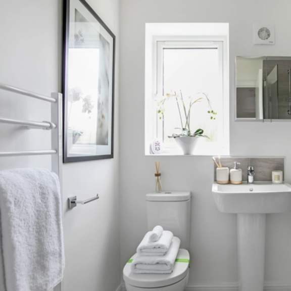 Thumbnail 3 of 5 a white bathroom with a sink and toilet and a window