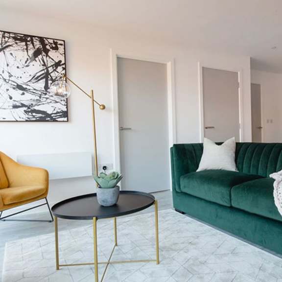 Thumbnail 4 of 7 a living room with a green couch and a table at Vox Apartments, Manchester, M15 4YD