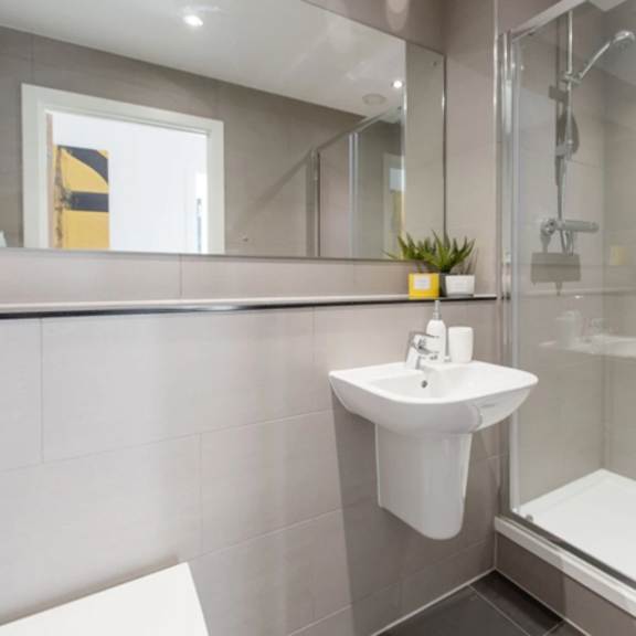 Thumbnail 6 of 7 a modern bathroom with a sink and a shower at Vox Apartments, Manchester, M15 4YD