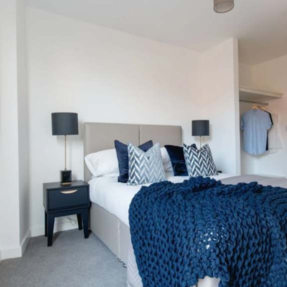 Thumbnail 1 of 7 a bedroom with a bed and a blue blanket at Vox Apartments, Manchester, M15 4YD