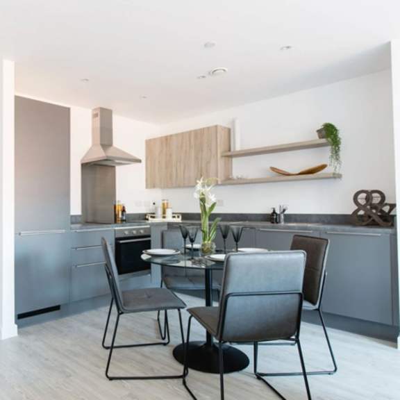 Thumbnail 3 of 7 a kitchen and dining area with a table and chairs at Vox Apartments, Manchester