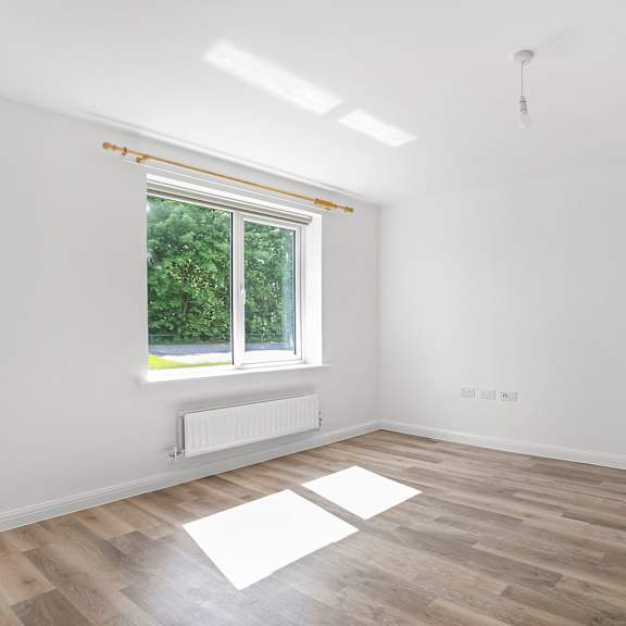 Thumbnail 2 of 5 an empty room with white walls and a window