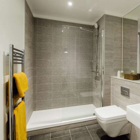 Thumbnail 2 of 8 A bathroom with a toilet, sink, and shower.at Slate Yard Apartments, Salford, M3 5EX