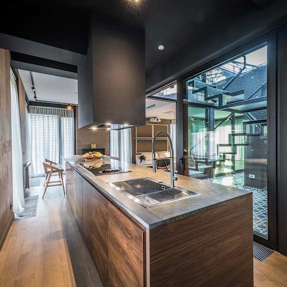 Thumbnail 3 of 3 A modern kitchen with a wooden island and a view of the dining area.