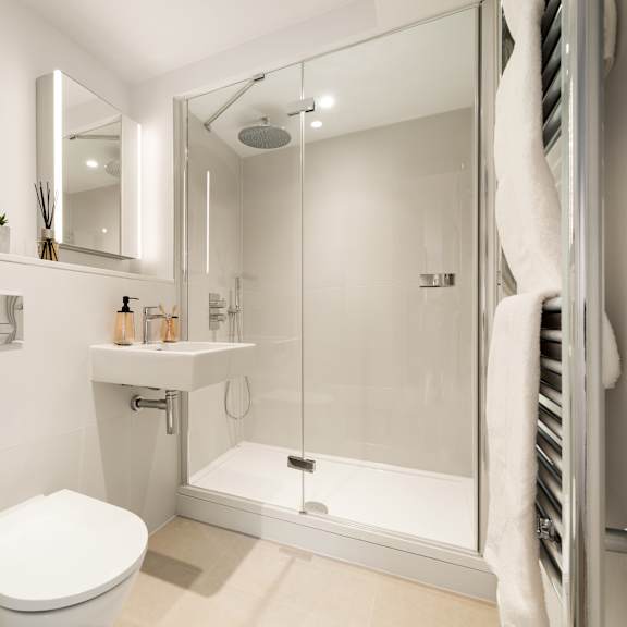 Thumbnail 4 of 4 A white toilet is in a small bathroom with a walk-in shower.