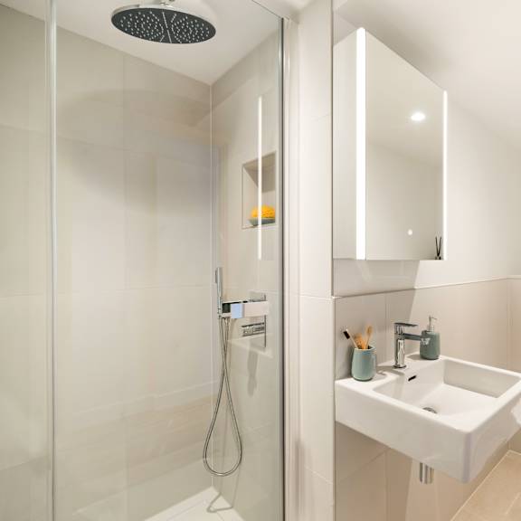 Thumbnail 4 of 4 A modern bathroom with a white sink and toilet.