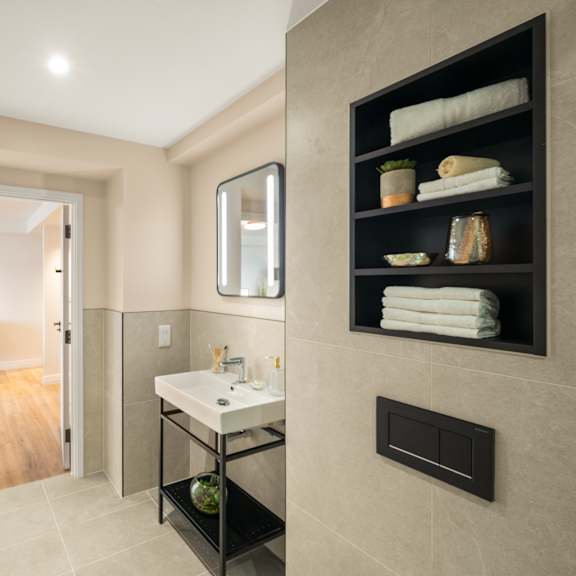 Thumbnail 5 of 5 A bathroom with a sink, mirror, and towel rack.