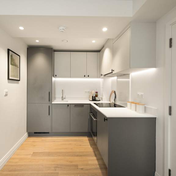 Thumbnail 2 of 5 A modern kitchen with a wooden floor and stainless steel appliances.
